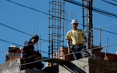 Construction workers reinforcing a new floor on a house